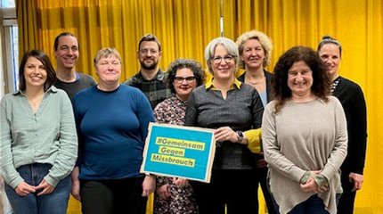 Die Bürgermeisterin von Walsrode und Mitarbeiterinnen und Mitarbeiter unterschiedlicher Einrichtungen vor einer Holztreppe.